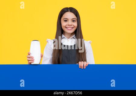 Ragazza adolescente con shampoos condizionanti o gel doccia. Prodotti cosmetici per la cura dei capelli per bambini, bottiglia di shampoo. Faccia della ragazza felice, emozioni positive e sorridenti Foto Stock