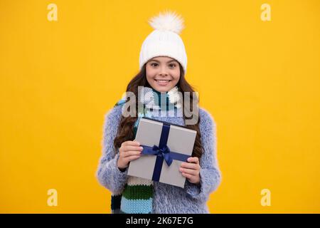 Bambino con regalo scatola su sfondo isolato. Regali per compleanno, San Valentino, Capodanno o Natale. Faccia felice della ragazza, positiva e. Foto Stock