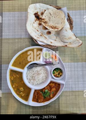 Delizioso pasto vegetariano indiano thali con riso e pane di roti Foto Stock