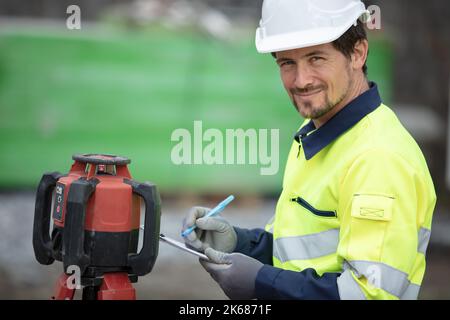 topografo terrestre al lavoro su un pozzo petrolifero europeo Foto Stock