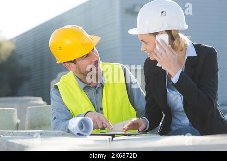 Due i lavoratori che operano al di fuori su di un sito in costruzione Foto Stock