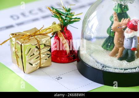 Natale neve globo, presente e campana 25th dicembre giorno di Natale sul calendario, conto alla rovescia per il grande giorno, spirito di festa Foto Stock