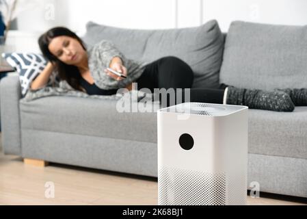Donna che utilizza purificatore d'aria, filtro antipolvere PM 2,5, aria pulita e salutare Foto Stock
