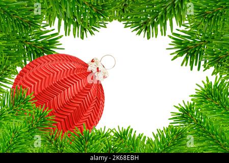 Dekoration für Weihnachten mit roter weihnachtskugel und Tannenzweigen auf weissem Hintergrund Foto Stock