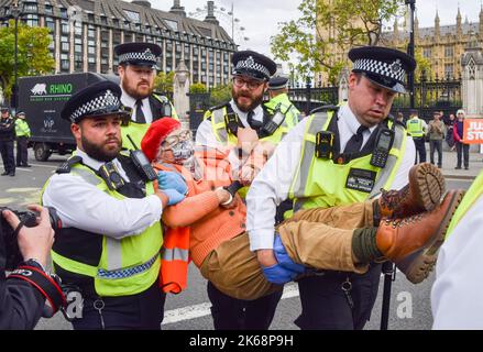 Londra, Inghilterra, Regno Unito. 12th Ott 2022. La polizia arresta un attivista insulato britannico che è stato incollato alla strada e bloccato il traffico in Piazza del Parlamento. Il gruppo chiede che il governo isoli tutte le case nel Regno Unito. (Credit Image: © Vuk Valcic/ZUMA Press Wire) Foto Stock