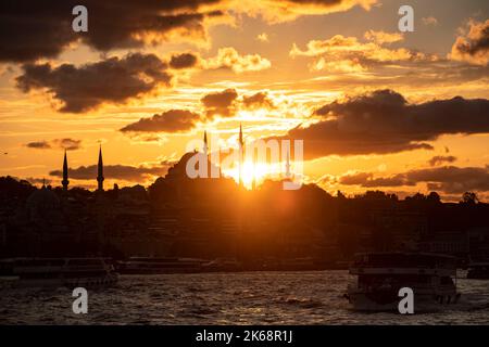 Il tramonto a Istanbul ha creato una splendida vista con la barca del passeggero che passa di fronte a una moschea di Suleymaniye. Foto Stock