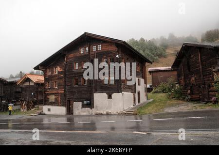 Antico granaio di raccard svizzero tradizionale in legno su pali di pietra nel vecchio quartiere di Hinterdorf di Zermatt Svizzera, tempo piovoso. Foto Stock