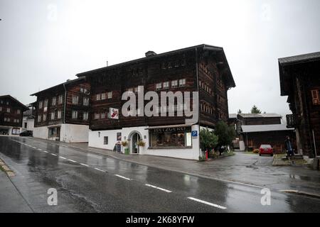 Antico granaio di raccard svizzero tradizionale in legno su pali di pietra nel vecchio quartiere di Hinterdorf di Zermatt Svizzera, tempo piovoso. Foto Stock