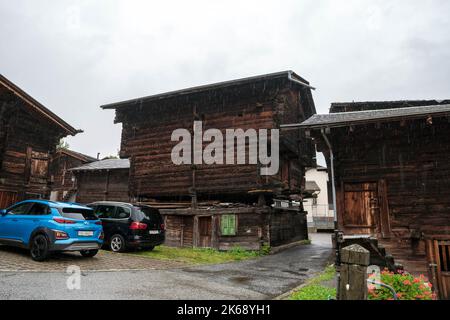 Antico granaio di raccard svizzero tradizionale in legno su pali di pietra nel vecchio quartiere di Hinterdorf di Zermatt Svizzera, tempo piovoso. Foto Stock