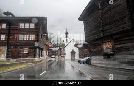 Antico granaio di raccard svizzero tradizionale in legno su pali di pietra nel vecchio quartiere di Hinterdorf di Zermatt Svizzera, tempo piovoso. Foto Stock