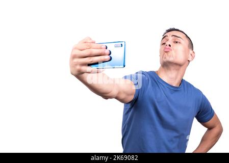 Uomo che prende un selfie mentre soffia un bacio con il cellulare Foto Stock