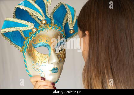 Il volto di una ragazza in una maschera di carnevale veneziana su uno sfondo isolato, mascherata e attore mascherato, teatro Foto Stock