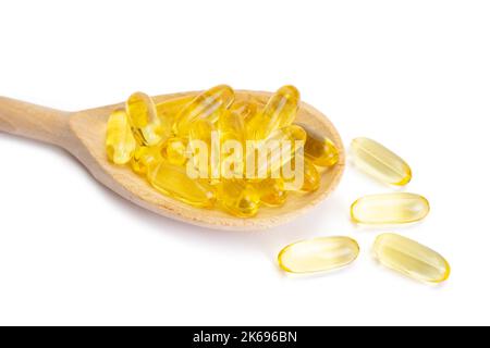 Pila di capsule Omega 3 in cucchiaio di legno isolato su fondo bianco. Softgels, compresse per la pelle, la salute, il trattamento delle malattie. Sanità, dieta, cuore Foto Stock