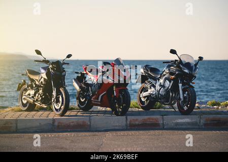 Izmir, Turchia - 25 settembre 2022: Gruppo di motociclette parcheggiate vicino al mare, colore blu marchio Yamaha MT09 e FZ600 e Honda CBR1000RR. Foto Stock