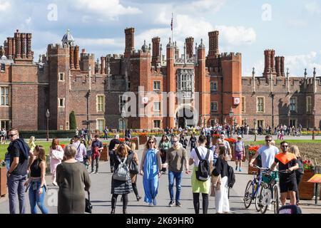 Turisti all'entrata principale dell'Hampton Court Palace, il Tudor Great Gatehouse, Richmond upon Thames, Londra, Inghilterra Regno Unito Foto Stock