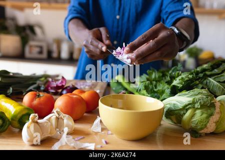 Parte centrale dell'uomo afroamericano in piedi in cucina e in cucina cena Foto Stock