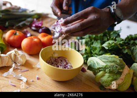 Parte centrale dell'uomo afroamericano in piedi in cucina e in cucina cena Foto Stock