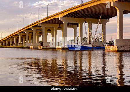 Una barca di gamberi viaggia lungo il fiume Pascagoula sotto il ponte alto del fiume Pascagoula, 4 ottobre 2022, a Pascagoula, Mississippi. Foto Stock