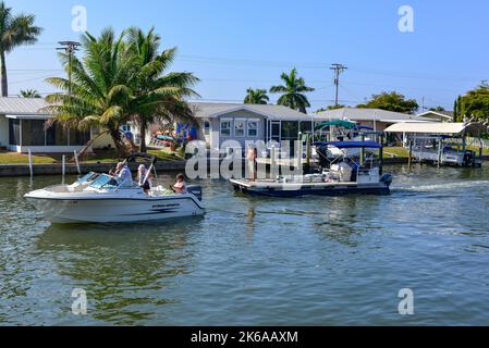 Persone in barca nella comunità nautica, sul canale vicino al porticciolo e Phuzzy's Boat Shack ristorante e bar a Saint James City, Pine Island, Florida Foto Stock