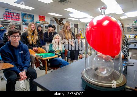 Gli studenti di chimica delle scuole superiori a San Clemente, California, prestano particolare attenzione alla dimostrazione di un palloncino che si gonfia nel vuoto. Foto Stock