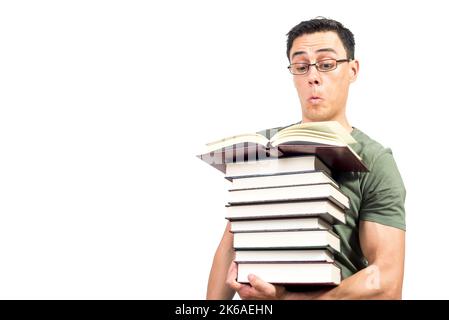 Curioso studente maschile in occhiali leggendo libri interessanti Foto Stock