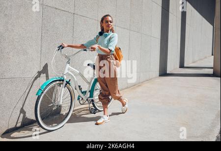 Bici, giovane donna di città e utilizzare la bicicletta in una giornata estiva all'aperto con un look alla moda, edgy o casual. Le ragazze si rilassano, guidano e riducono l'impronta di carbonio Foto Stock