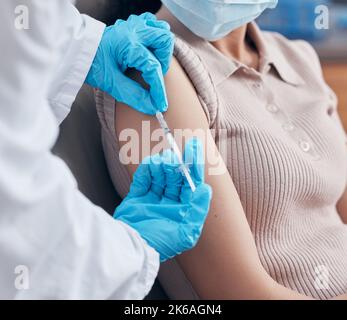 Darsi una spinta immunitaria. Una donna che riceve un colpo di vaccinazione dal suo medico. Foto Stock