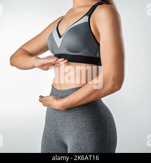 Mangiare bene è la forma più alta di auto-rispetto. Studio shot di una donna irriconoscibile incorniciare il suo stomaco con le mani su uno sfondo grigio. Foto Stock