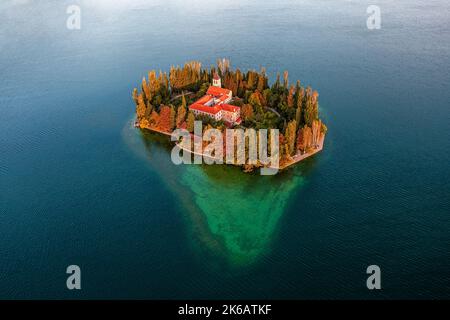 Visovac, Croazia - veduta aerea del meraviglioso monastero cristiano Visovac nel Parco Nazionale di Krka in una luminosa mattinata autunnale con calde luci dorate Foto Stock