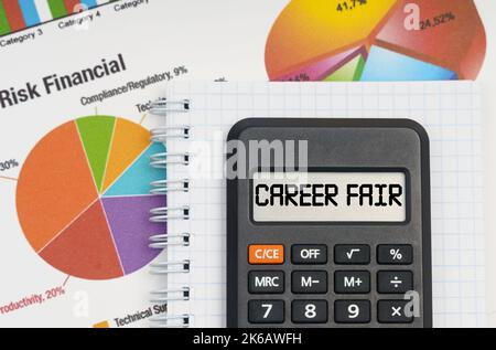 Business e concetto di economia. Sulla tabella sono le tabelle, un taccuino e una calcolatrice con l'iscrizione - Career Fair Foto Stock
