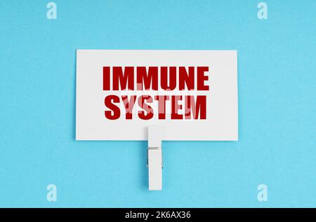 Concetto di medicina. Su uno sfondo blu, ci sono pillole e un biglietto da visita con l'iscrizione - SISTEMA IMMUNITARIO Foto Stock