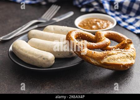 Salsicce bianche tradizionali bavaresi sul piatto e pretzes. Foto Stock