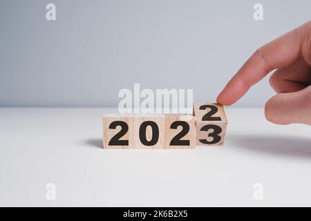 Blocchi di legno con cambio numero 2022 2023. Concetto di nuovo anno. Spazio di copia. Sfondo bianco Foto Stock