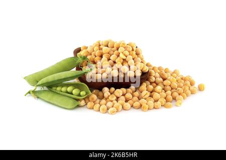 Secchi piselli gialli interi e piselli verdi dolci con foglie verdi su sfondo bianco Foto Stock