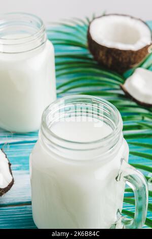 Layout creativo composto da noci di cocco e foglie tropicali. Concetto di cibo Foto Stock