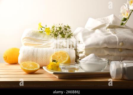 Rimedio domestico per lavare i vestiti in modo sostenibile e naturale con limone, bicarbonato e aceto con i vestiti su un tavolo di legno. Vista dall'alto. Orizzonte Foto Stock