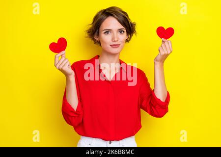 Ritratto di bella bella bella bella adorabile ragazza con pettinatura bob indossare camicia rossa braccia tenere rosso come piace isolato su sfondo giallo colore Foto Stock