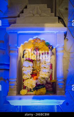 Un piccolo idolo del Signore Hanuman che è adorato in un tempio a Mumbai, India Foto Stock