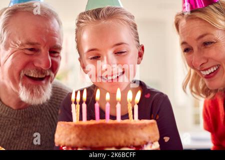 Nonni con nipote che festeggiano il compleanno insieme a Party at Home Foto Stock