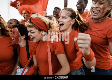 Gli appassionati di calcio si divertono a supportare la loro squadra preferita: Il concetto di sport di calcio per l'intrattenimento Foto Stock