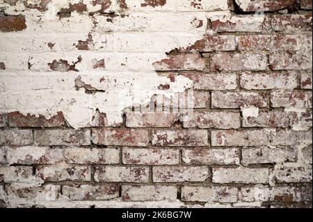 Vecchio muro di mattoni con vernice sfaldante per pelatura Foto Stock