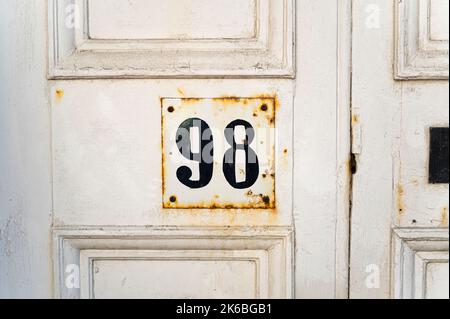 Vecchia porta in legno bianco e rudoso e intemperiato con dettagli dipinti a mano in 98 Foto Stock