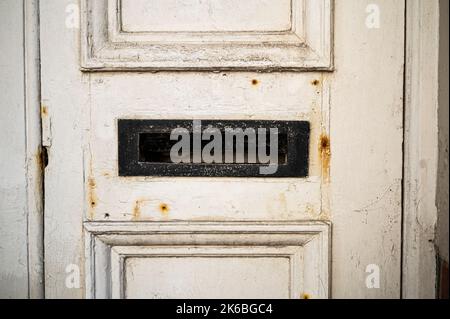 Vecchio porta in legno bianco e rudoso e intemperiato con dettaglio Letterbox Foto Stock