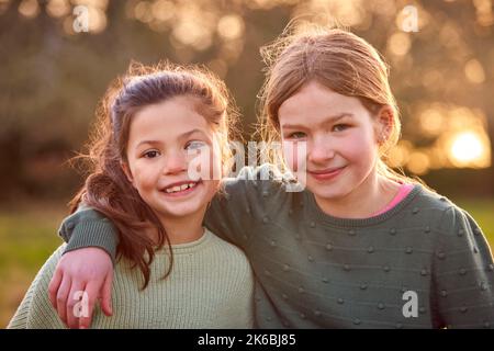 Ritratto di due ragazze all'aperto con le braccia l'una intorno all'altra Foto Stock