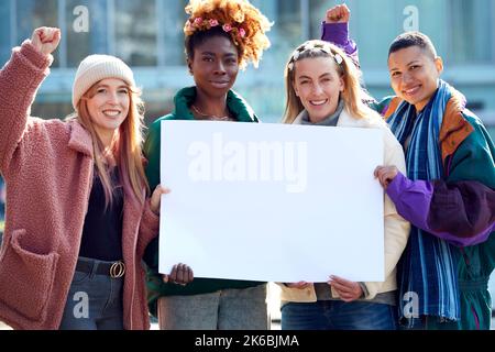 Ritratto delle manifestanti femminili che tiene il Placard vuoto sulla dimostrazione marzo Foto Stock