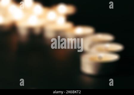 Candele di sbavatura su vetro decorativo. Sfondo scuro. Sfocatura Foto Stock