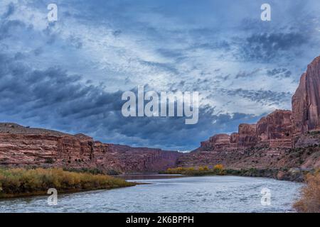 Nuvole tempestose prima dell'alba sulle scogliere di arenaria di Wingate lungo il fiume Colorado Foto Stock