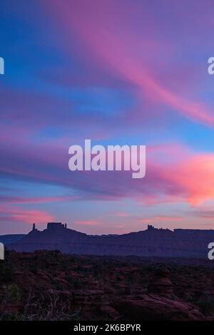 Nuvole pastello al tramonto sulla Torre di Castleton / Castle Rock, la canonica e il sacerdote e le monache vicino a Moab, Utah. La formazione rocciosa Madre superiore è una Foto Stock