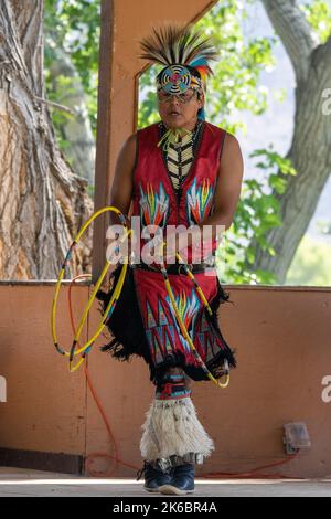 Navajo ballerina di canestro dei nativi americani in regalia che si esibisce in un festival a Moab, Utah. Dietro c'è un cantante j batterista. Foto Stock