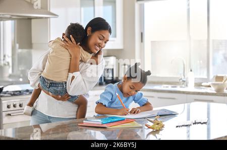 Tutto sembra buono qui. Una giovane madre che aiuta sua figlia con i compiti a casa. Foto Stock